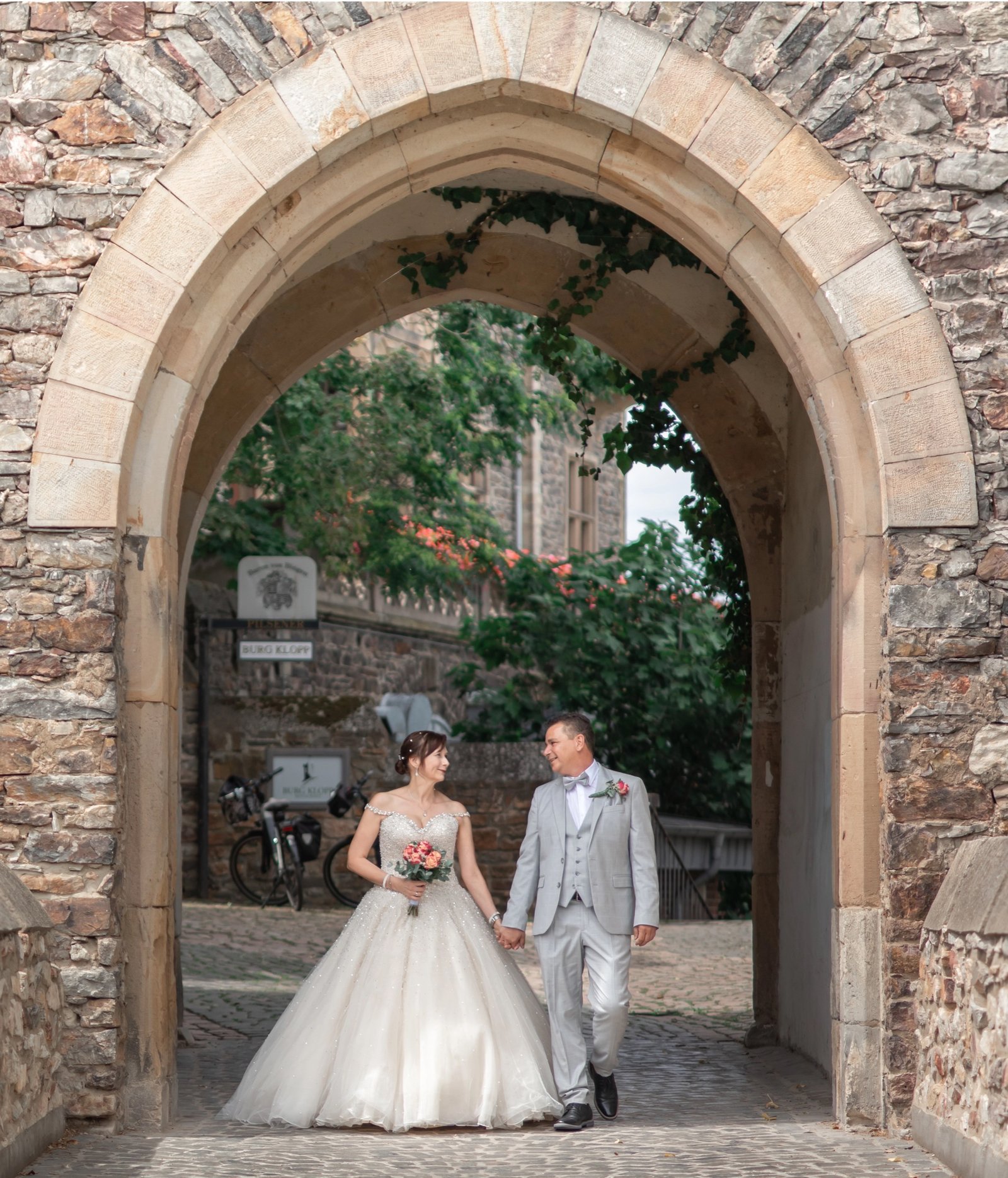 Brautkleid-Detail mit herzförmigem Brautstrauß aus roten und weißen Rosen